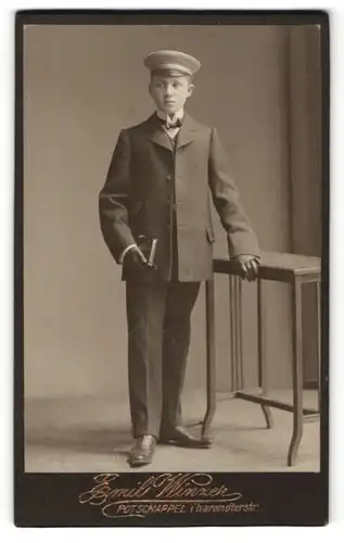 Fotografie Emil Winzer, Potschappel, Junge in Anzug mit Mütze und Handschuhen an