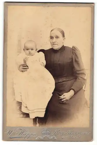 Fotografie W. Happe, Königs Wusterhausen, Portrait nette Grossmutter mit niedlichem Baby im Taufkleid