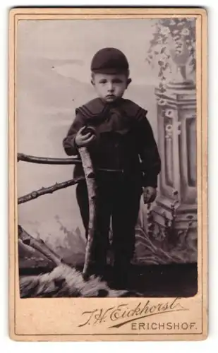 Fotografie J. H. Eickhorst, Weyhe-Erichshof, Portrait kleiner Junge mit Kappe an Zaun glehnt