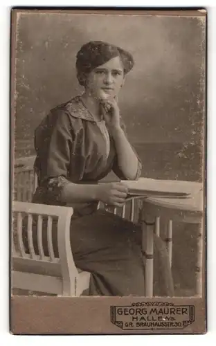 Fotografie Georg Maurer, Halle a / S., Portrait junge Dame im modischen Kleid mit Buch am Tisch sitzend