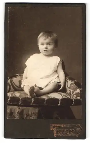 Fotografie Atelier Strauss, Leipzig, Portrait eines niedlichen Babys im Hemdchen in einem Sessel