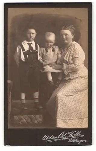 Fotografie Ad. Kolle, Göttingen, Portrait bezaubernde Mutter im Kleid mit zwei niedlichen Buben