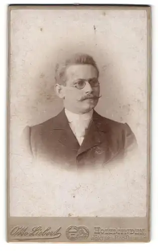 Fotografie Otto Liebert, Holzminden, Höxter & Bad-Driburg, Portrait charmanter Herr mit Brille u. Zwirbelbart im Anzug