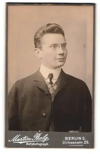 Fotografie Martin Balg, Berlin-C, Portrait junger Herr mit zurückgekämmtem Haar mit Zwicker