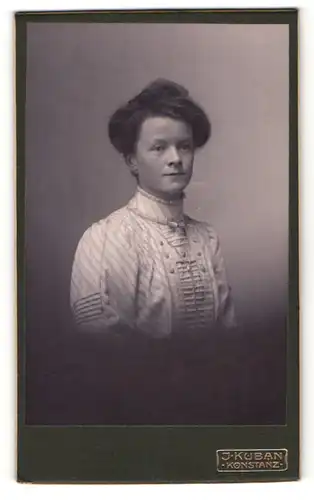 Fotografie J. Kuban, Konstanz, Elegante Dame mit Hochsteckfrisur in hochgeschlossenem gestreiften Kleid