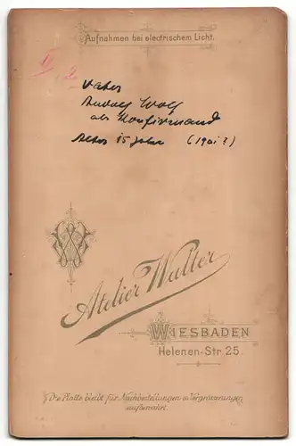 Fotografie Atelier Walter, Wiesbaden, Portrait junger Herr im Anzug mit Buch an Tisch gelehnt