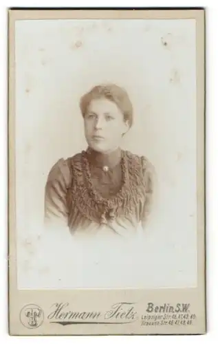 Fotografie Hermann Tietz, Berlin S. W., Portrait junge Dame mit zurückgebundenem Haar im eleganten Kleid