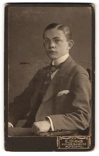 Fotografie E. Dirks, Hildesheim, Portrait halbwüchsiger Knabe mit Zwicker in Anzug mit Krawatte