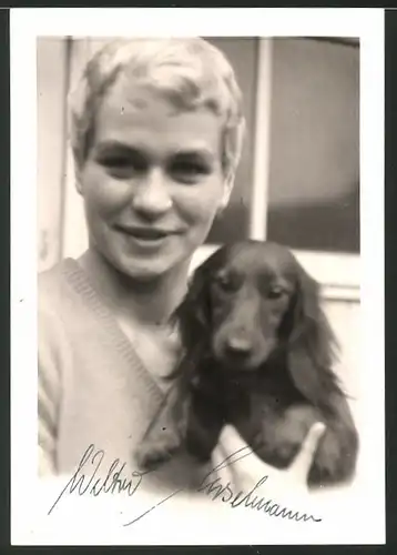 Fotografie blonder Bursche mit Hund - Dackel im Arm