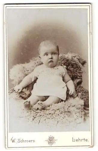 Fotografie W. Schroers, Lehrte, Baby auf Felldecke sitzend
