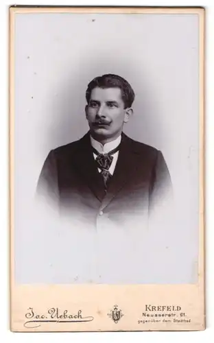 Fotografie Jac. Uebach, Krefeld, Portrait charmanter Herr mit Krawatte im Anzug