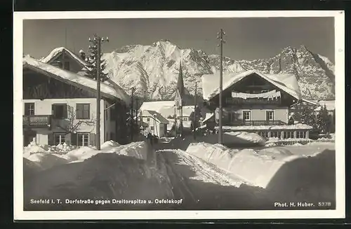 AK Seefeld i. T., Dorfstrasse gegen Dreitorspitze u. Oefelkopf im Winter