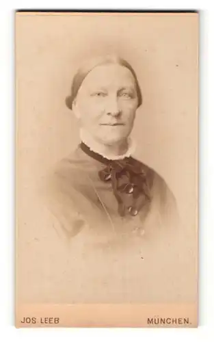 Fotografie Jos. Leeb, München, Portrait betagte Dame mit freundlichem Blick und Schleife am Kragen