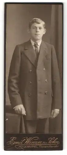Fotografie Emil Winzer & Sohn, Potschappel, Portrait junger Herr mit Krawatte im Anzug an Tisch gelehnt