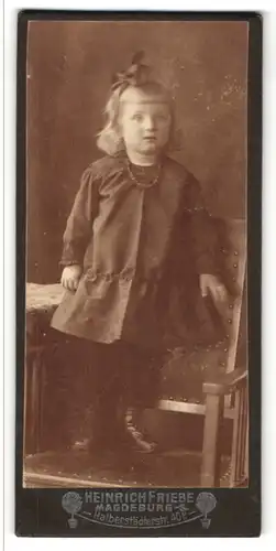 Fotografie Heinrich Friebe, Magdeburg-S., Portrait kleines Mädchen im hübschen Kleid auf Stuhl stehend