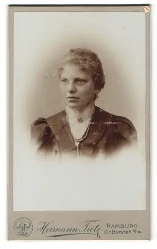 Fotografie Hermann Tietz, Hamburg, Portrait junge hübsche Dame mit Kragenbrosche u. Perlenkette