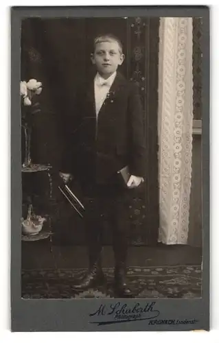 Fotografie M. Schuberth, Kronach, Portrait frecher blonder Bube mit Buch im Anzug