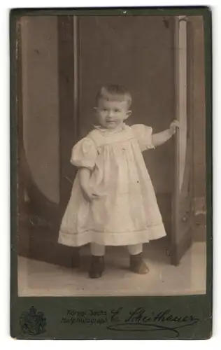 Fotografie E. Scheithauer, Zwickau i. S., Portrait lachendes kleines Mädchen im weissen Kleidchen mit Schnürschuhen