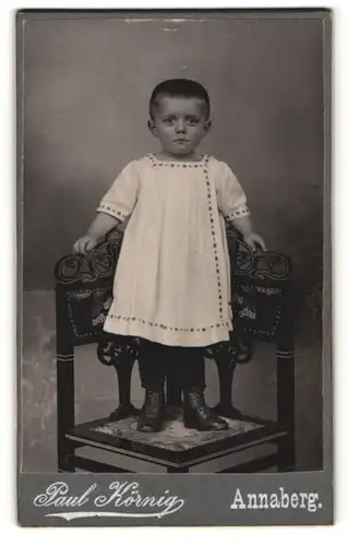 Fotografie Paul Körnig, Annaberg, Portrait zuckersüsses Kleinkind im weissen Hemdchen und Schnürstiefelchen