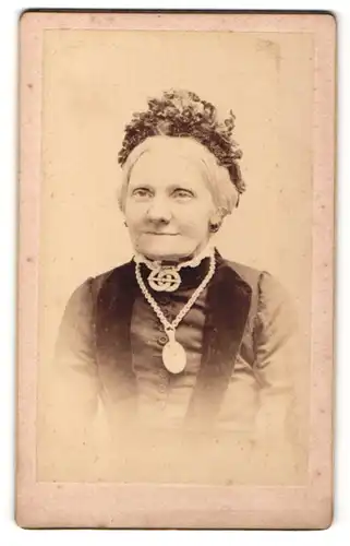 Fotografie unbekannter Fotograf und Ort, Portrait betagte Dame in feierlicher Kleidung mit Kopfschmuck