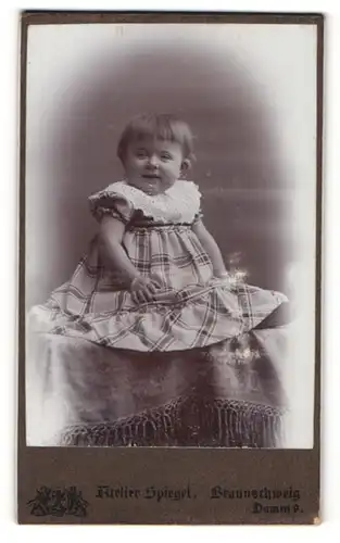 Fotografie Atelier Spiegel, Braunschweig, Portrait lachendes kleines Mädchen im karierten Kleid