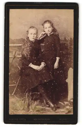 Fotografie Edmund Frede, Münster, Portrait zwei Mädchen in hübschen Kleidern an Zaun gelehnt