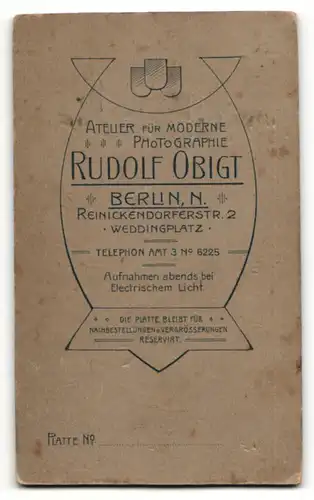 Fotografie Rudolf Obigt, Berlin, Portrait niedliches Kleinkind im weissen Hemd auf Sessel sitzend