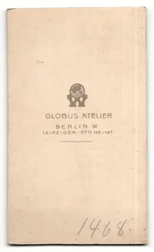 Fotografie Atelier Globus, Berlin, Portrait frech grinsender Bube im schwarzen Anzug