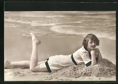 AK Junge Frau im Sand am Strand liegend, Bademode