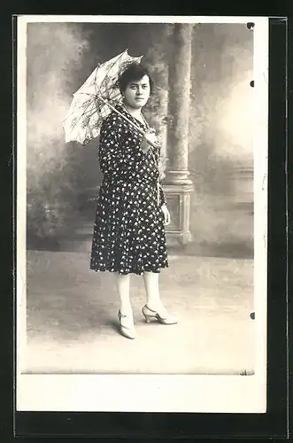 Foto-AK Frau mit Schirm vor Studiokulisse