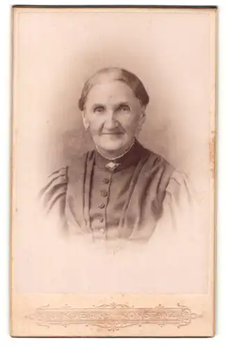 Fotografie J. Kuban, Konstanz, Portrait Greisin mit zusammengebundenem Haar