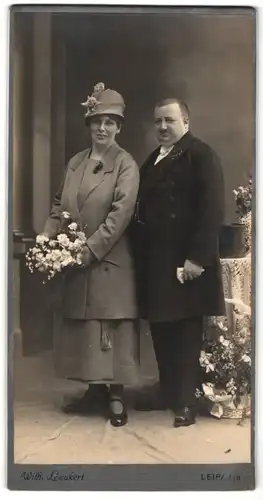 Fotografie Wilhelm Leukert, Leipa i. B., beleibter Mann nebst Dame mit Hut und Blumenstrauss