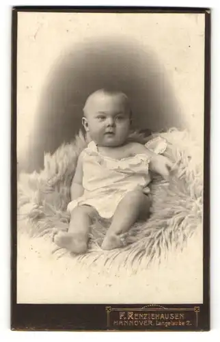 Fotografie F. Renziehausen, Hannover, Süsses Baby auf einem Fell porträtiert