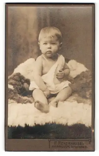 Fotografie F. Renziehausen, Hannover, Portrait Baby sitzt auf einem Fell