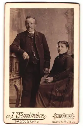 Fotografie J. Weisskirchen, Augsburg, Portrait älteres Paar in zeitgenöss. Kleidung