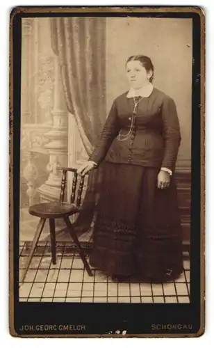Fotografie Joh. Georg Gmelch, Schongau, Frau mit Kleid an Stuhl lehnend