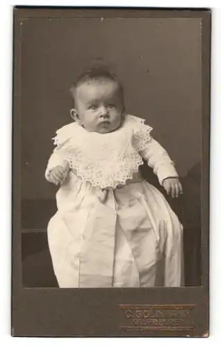 Fotografie C. Goldmann, Kaufbeuren, Baby in hellem Kleid mit Spitzenkragen