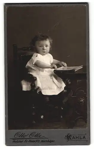 Fotografie Otto Otte, Kahla, Kind sitzt mit Buch an einem Tisch