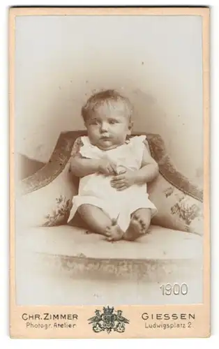Fotografie Chr. Zimmer, Giessen, Baby in weissem Kleid auf Sessel