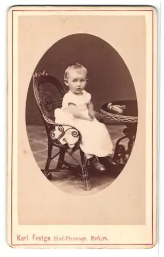 Fotografie Karl Festge, Erfurt, Portrait kleines Mädchen im weissen Kleid am Tisch sitzend