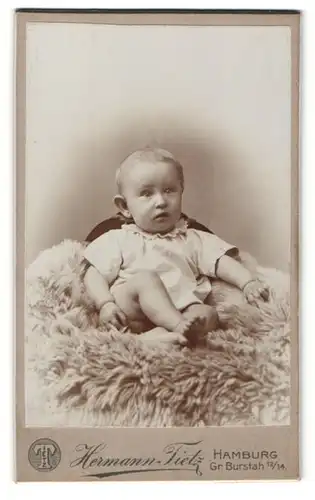 Fotografie Hermann Tietz, Hamburg, Kleinkind auf einem Schaffell