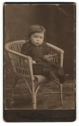 Fotografie Georg Brinker, Bremen, Niedliches Mädchen auf einem Korbstuhl