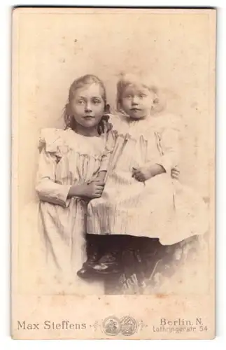 Fotografie Max Steffens, Berlin-N, Portrait zwei kleine Mädchen in hübschen Kleidern sich an den Händen haltend