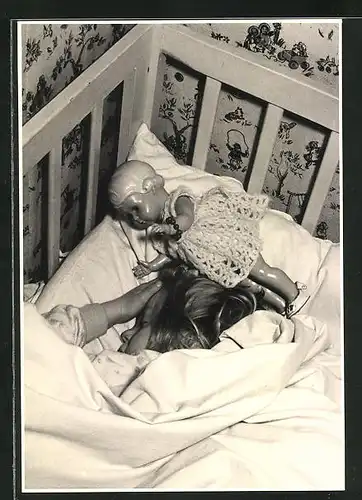Foto-AK Mädchen schläft mit seiner Puppe im Gitterbett