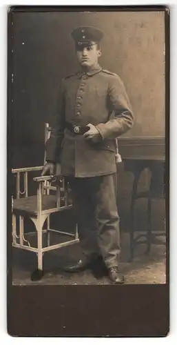 Fotografie Soldat in feldgrauer Uniform mit Mütze