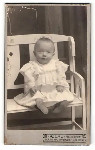 Fotografie W. Lau, Hartha, Portrait lachendes süsses Kleinkind im weissen bestickten Kleidchen