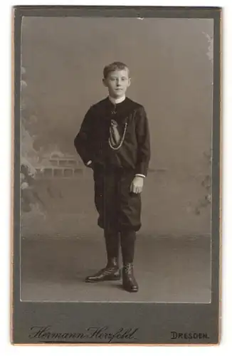 Fotografie Hermann Herzfeld, Dresden, Portrait niedlicher Bube mit Schnürschuhen im Anzug