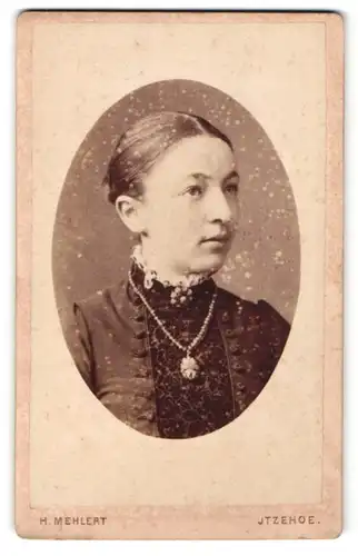 Fotografie H. Mehlert, Itzehoe, Portrait junge Dame mit zurückgebundenem Haar u. Kragenbrosche