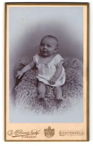 Fotografie F. Wenning, Lichtenfels, Baby in Hemdchen auf Fell