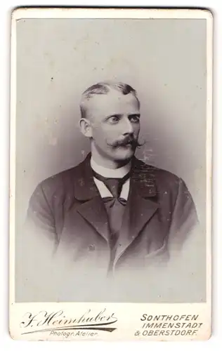 Fotografie J. Heimhuber, Sonthofen, Herr mit Schnurrbart in Anzug mit Krawatte
